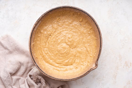 Wet and dry ingredients used for the banana bread combined in a large mixing bowl.