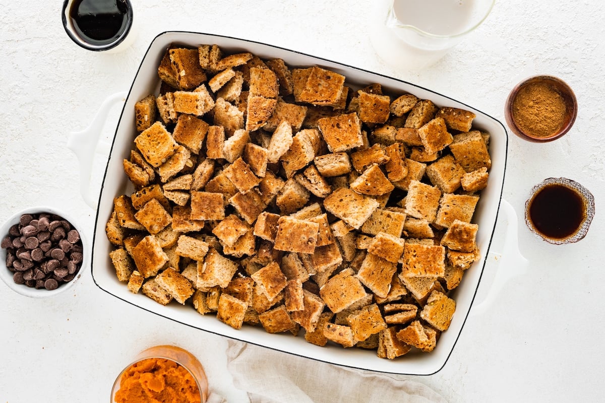 Toast cut into squares in a large square baking dish.