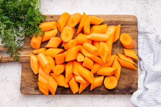 Cut carrots on a wooden cutting board.