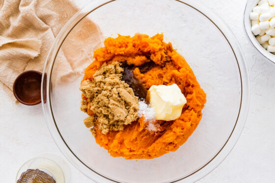 Mashed sweet potato sugar, salt, butter, and vanilla in a large glass bowl.