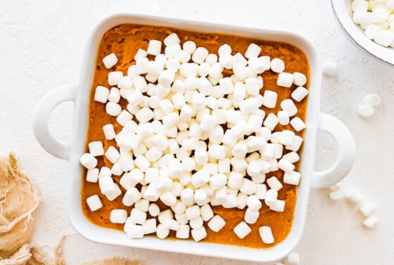 Sweet potato casserole in a square baking dish, topped with mini marshmallows.