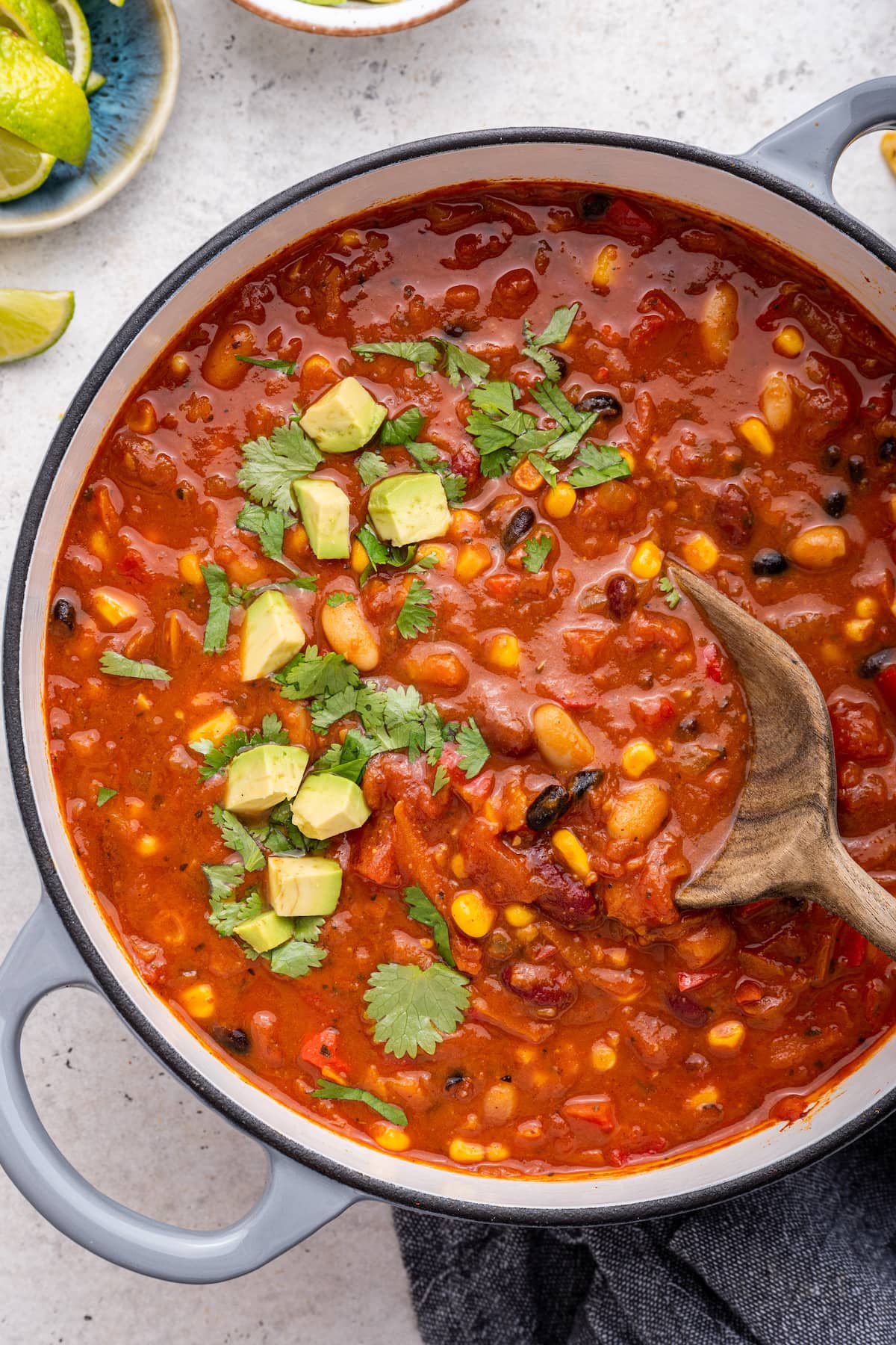 Vegetarian chili in a large pot with a wooden spoon.