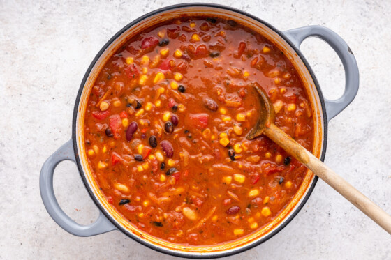 Vegetarian chili in a large pot with a wooden spoon.