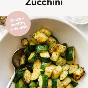 Bowl of ​Air Fryer Zucchini with a serving spoon.