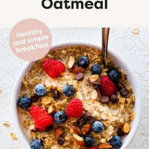 Bowl of oatmeal topped with berries, almonds and chocolate chips.