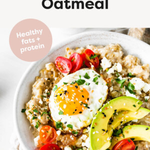 Bowl of oatmeal topped with an egg, tomatoes, avocado, feta and everything bagel seasoning.