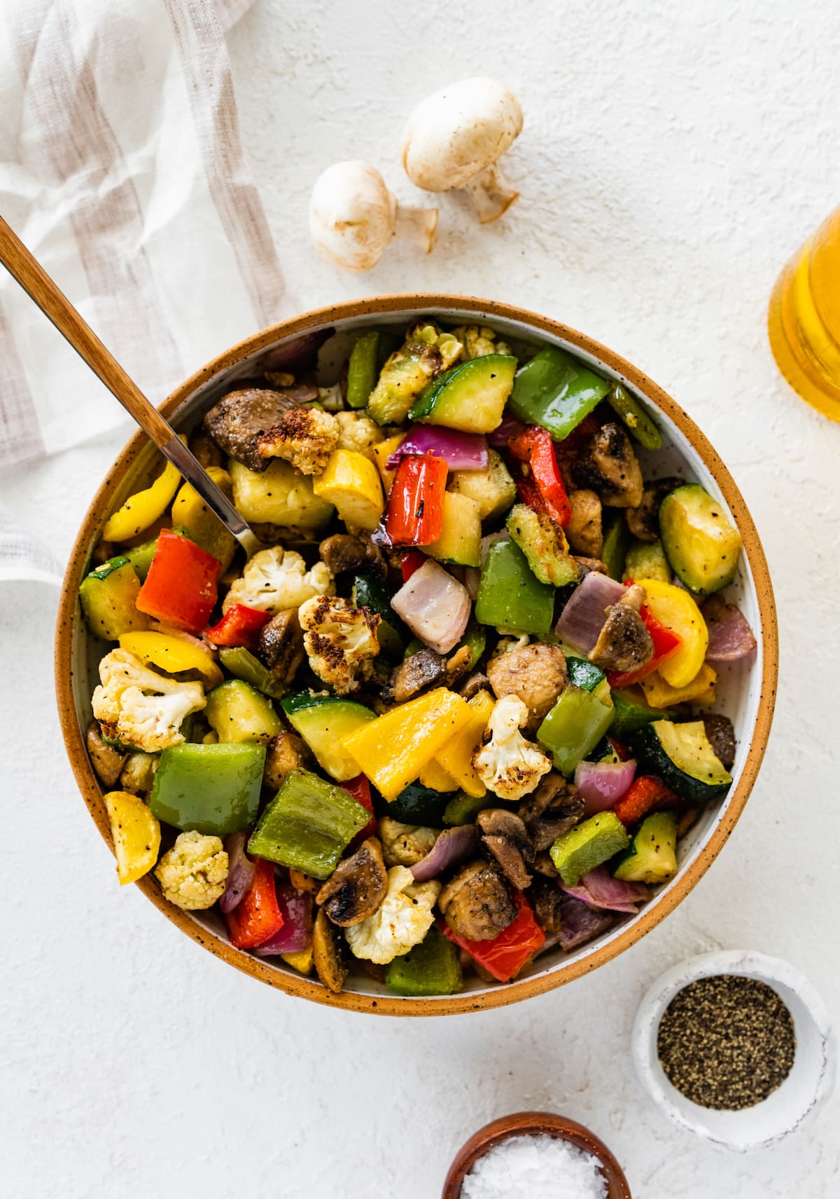 Air-fried vegetables in a bowl. Vegetables include cauliflower, mushroom, onion, zucchini, and bell peppers.