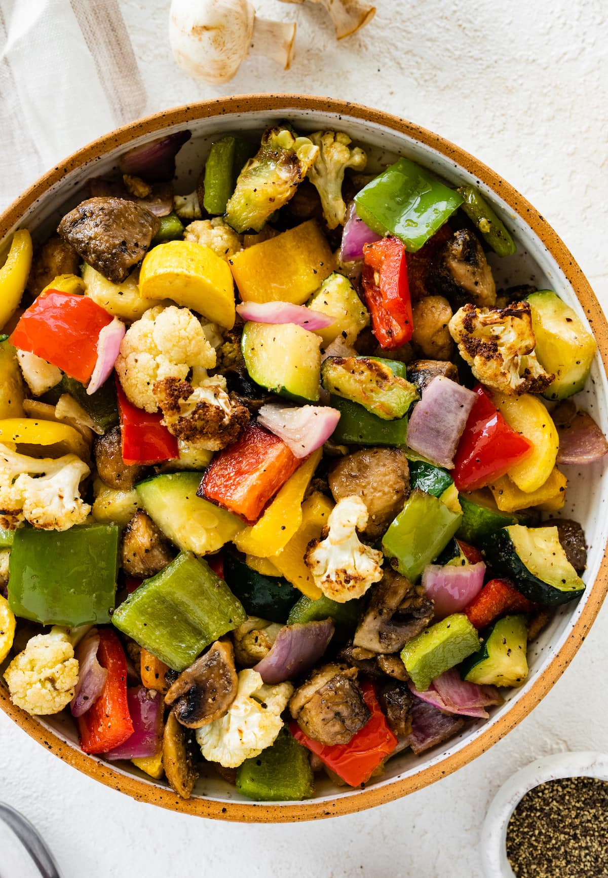Air-fried vegetables in a bowl. Vegetables include cauliflower, mushroom, onion, zucchini, and bell peppers.