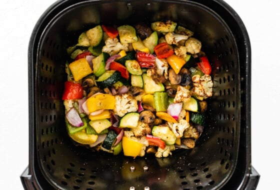 Vegetables in an air fryer basket after being air-fired.