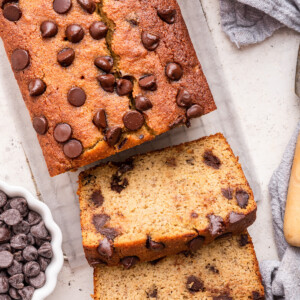 Almond flour banana bread with chocolate chips cut in two slices on a cooling rack.