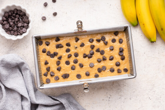 Almond flour banana bread before being baked and topped with chocolate chips in a bread pan.