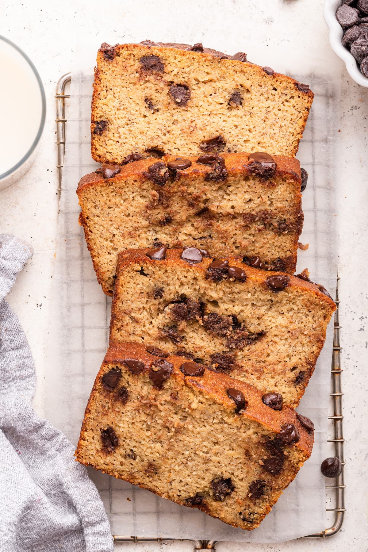 Multiple slices of almond flour banana bread with chocolate chips on a cooling rack.