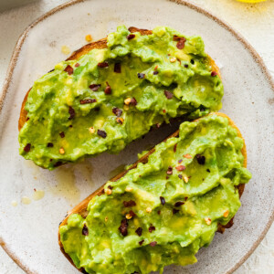 Plain avocado toast on a white plate.