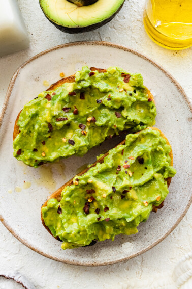 Plain avocado toast on a white plate.