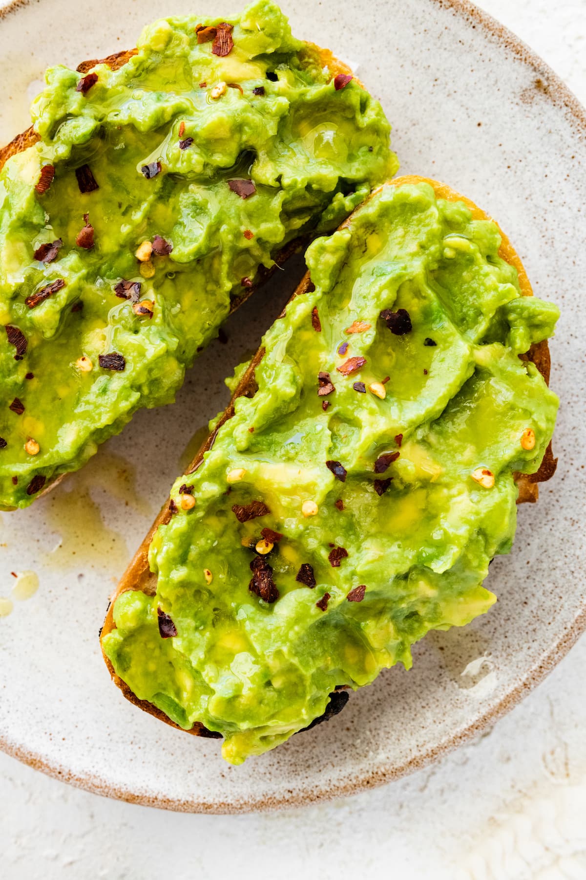 Plain avocado toast on a white plate.