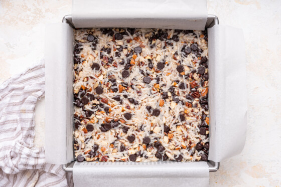 Chocolate coconut bars in a square baking dish before being baked.