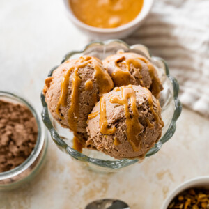 Chocolate peanut butter protein icee cream scooped in an ice cream bowl drizzled with peanut butter.