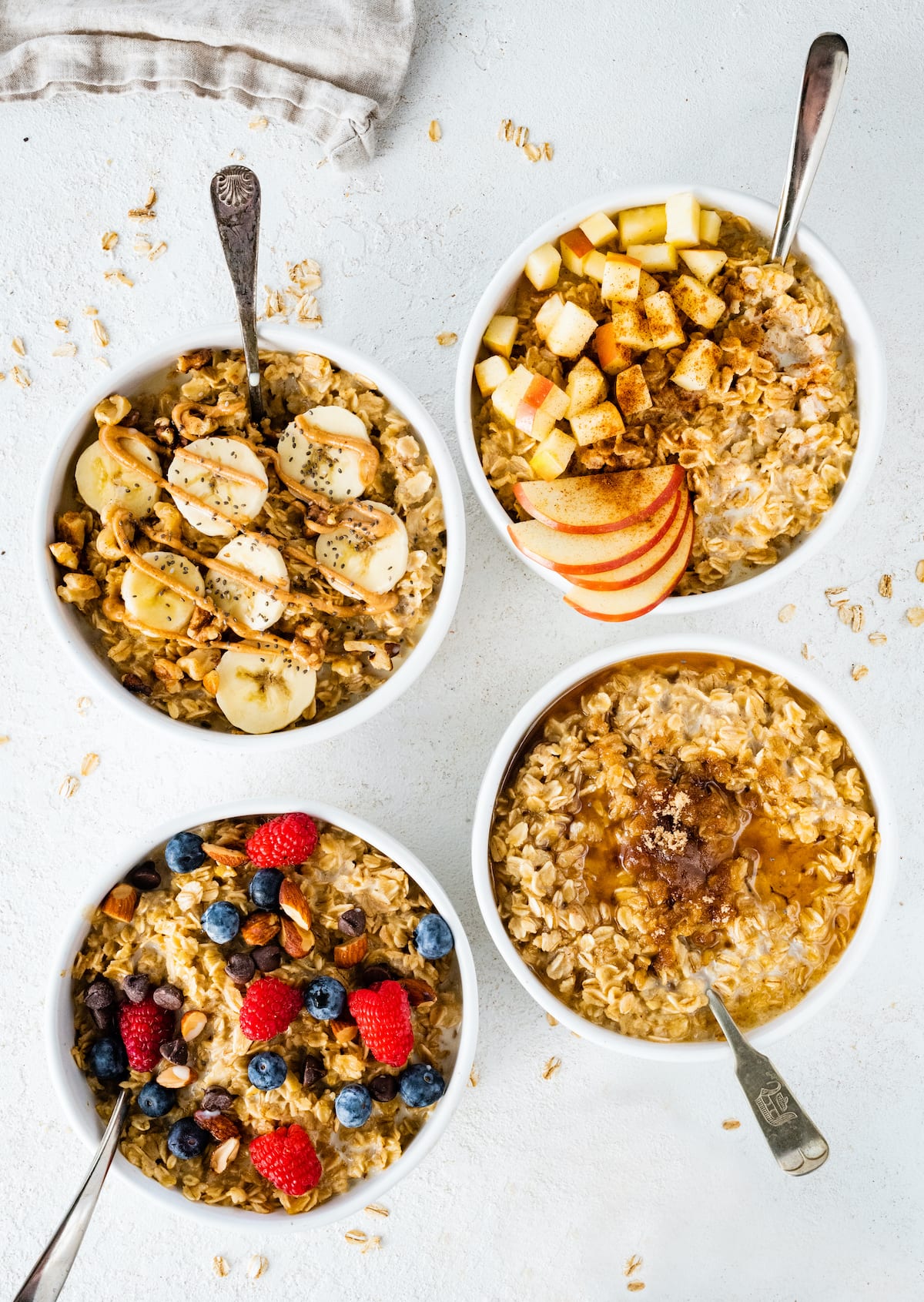 Four bowls of different oatmeal flavor variations: banana nut, apple cinnamon, maple brown sugar and berry almond.