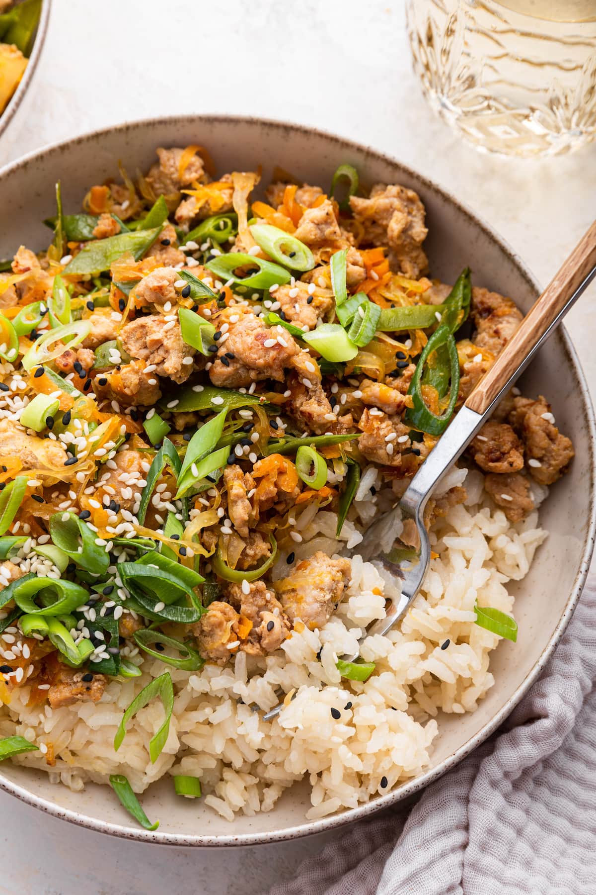 Tamari ground turkey skillet recipe served in a bowl with white rice and topped with green onions and sesame seeds.