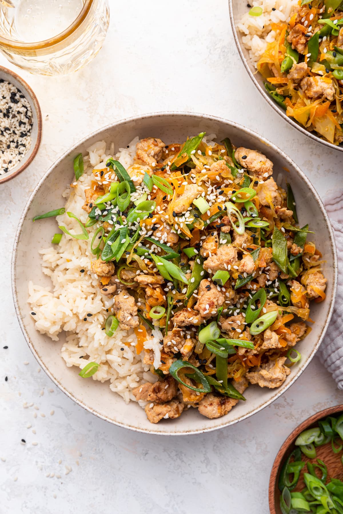 Tamari ground turkey skillet recipe served in a bowl with white rice and topped with green onions and sesame seeds.