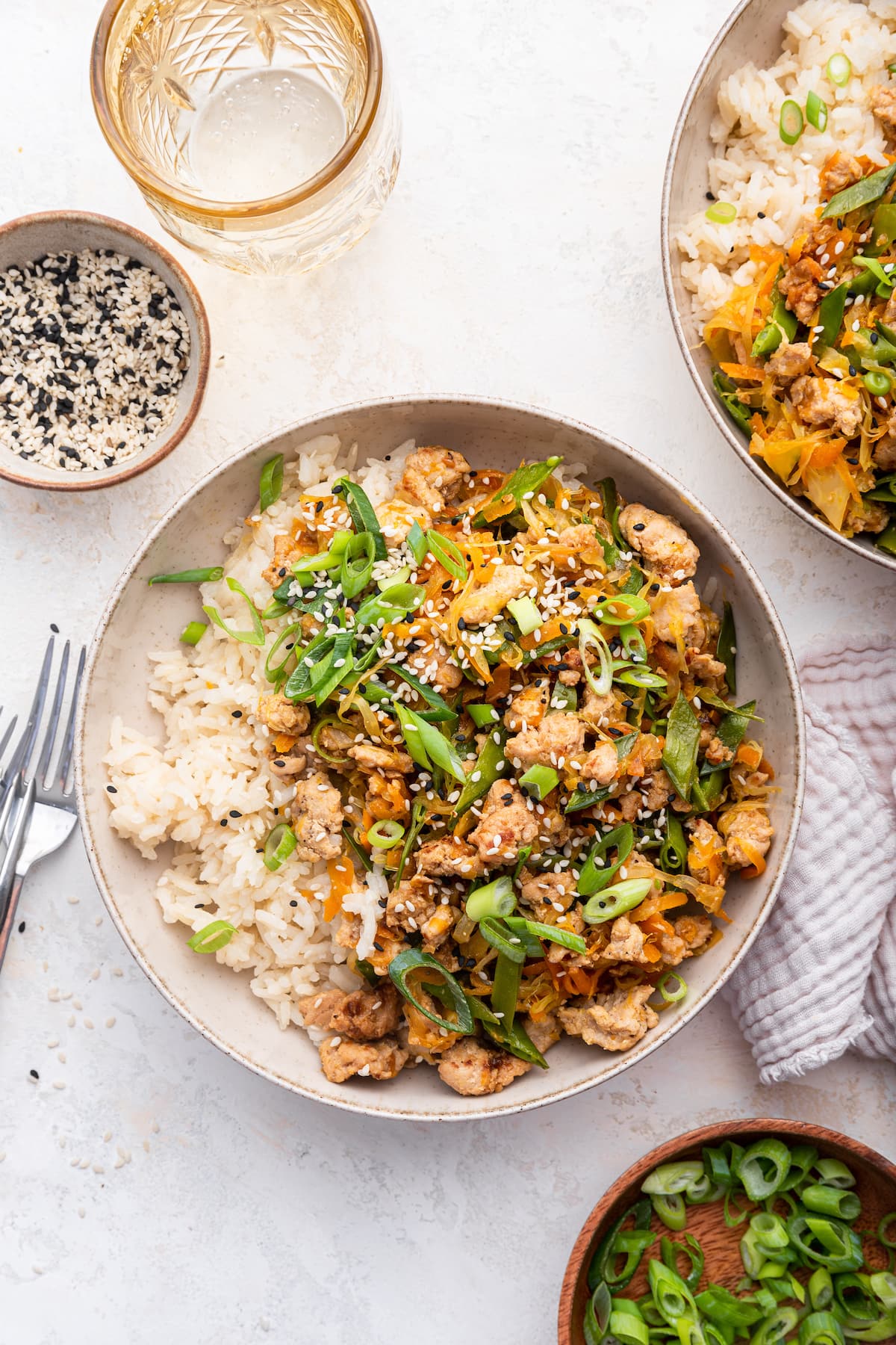 Tamari ground turkey skillet recipe served in a bowl with white rice and topped with green onions and sesame seeds.