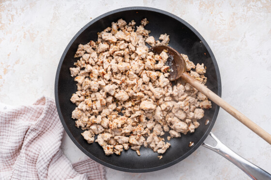 Ground turkey being cooked in a skillet.