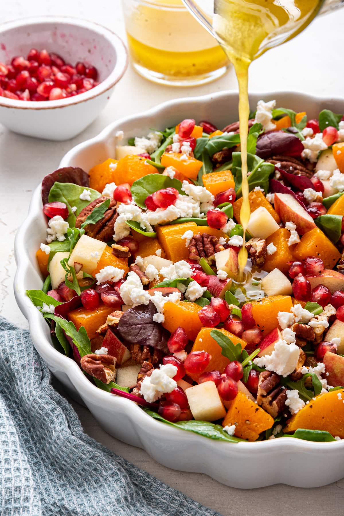 Dressing being poured onto the winter salad.