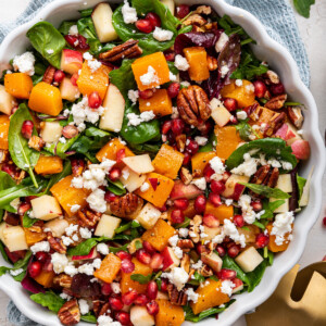 Winter salad being served in a white bowl.