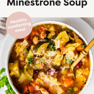 Slow Cooker Minestrone Soup in a bowl served with parm and a spoon.