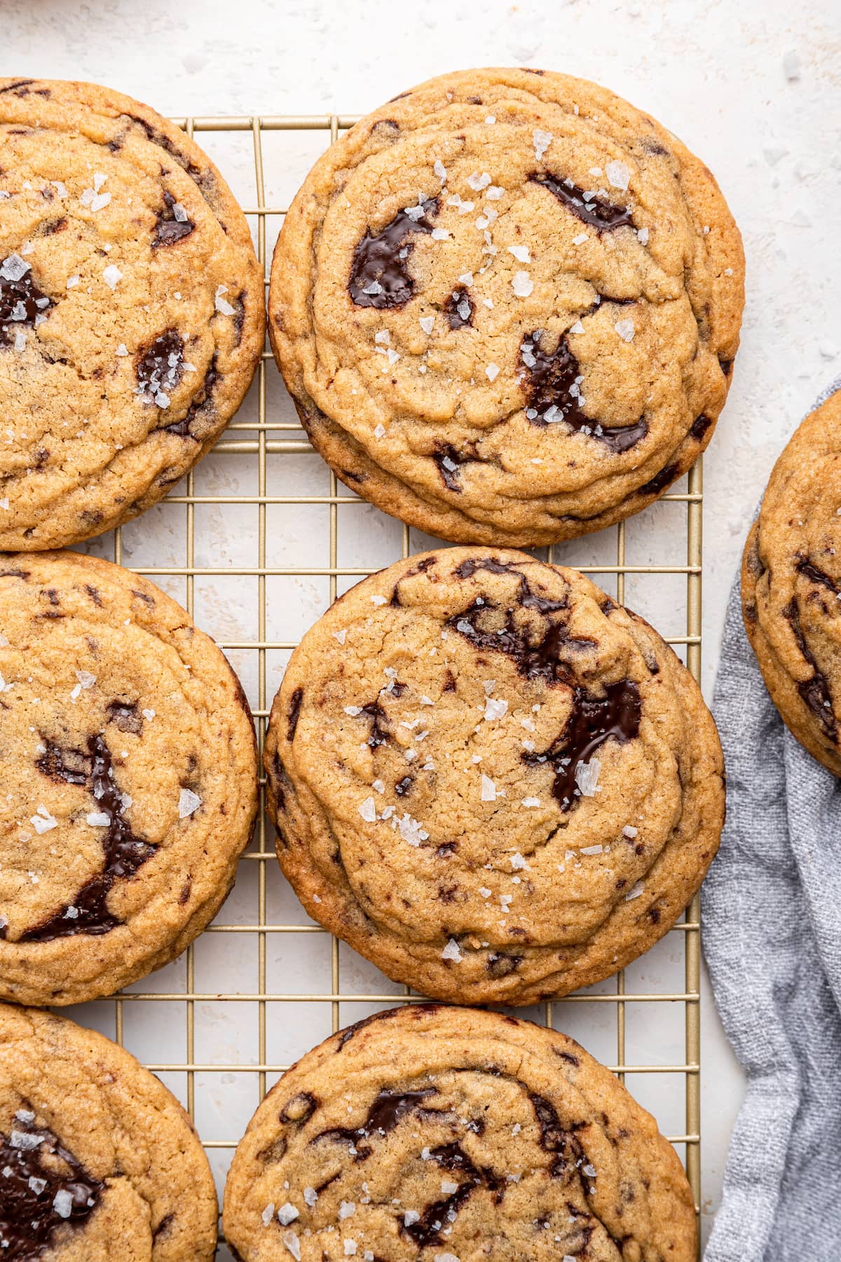 Brown butter chocolate chip cookies lined up on a wire rack.