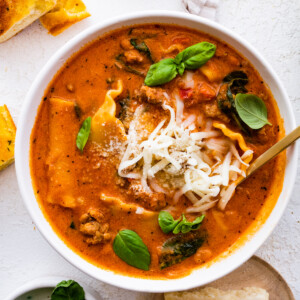 Lasagna soup in a bowl, garnished with Parmesan cheese and fresh basil.