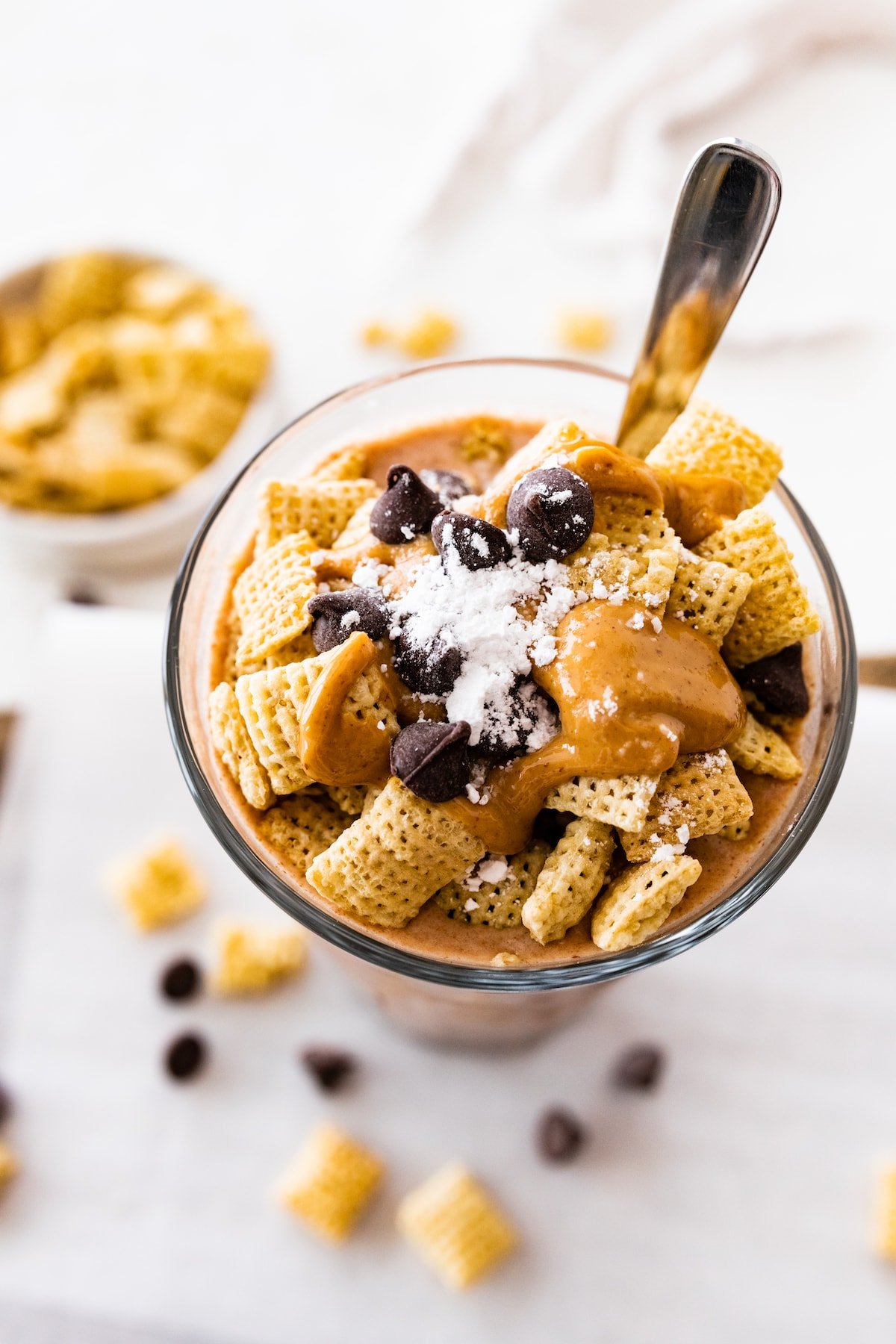 Muddy buddy protein shake in a large glass cup with a spoon.