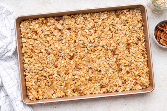 Protein granola spread out on a baking tray before being baked.
