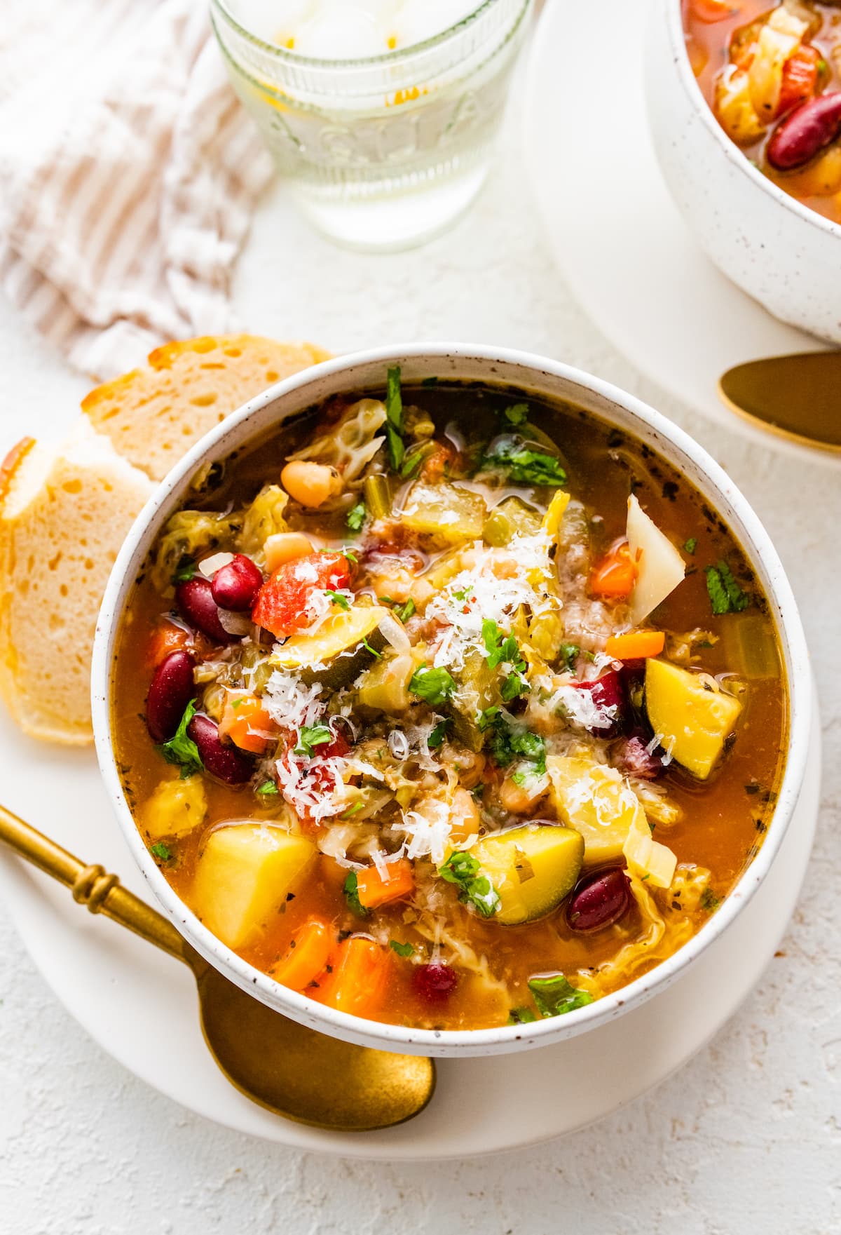 Minestrone soup in a bowl on a plate.