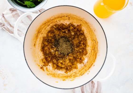 Sauted onions with herbs and spices in a large pot.