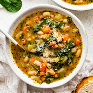 White bean soup in a bowl, garnished with parmesan cheese.