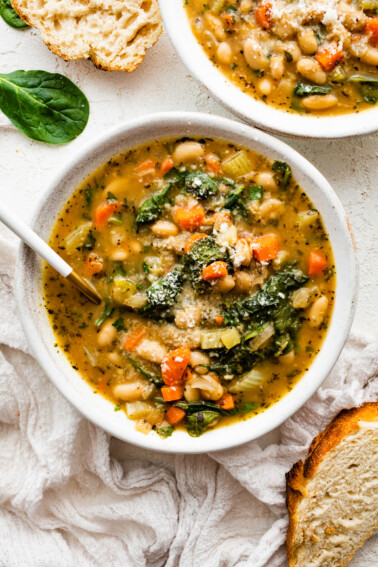 White bean soup in a bowl, garnished with parmesan cheese.