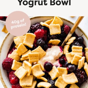 Yogurt bowl topped with frozen berries and Catalina Crunch cereal.