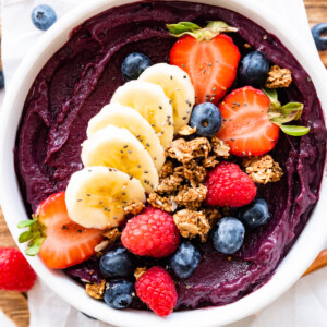 An acai bowl topped with fresh berries, sliced banana, and granola.