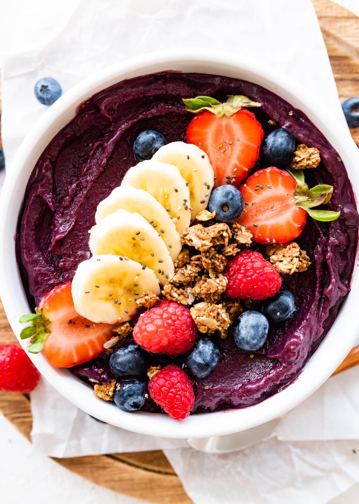 An acai bowl topped with fresh berries, sliced banana, and granola.