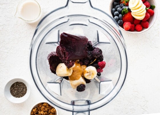 Frozen acai, berries, banana, and nut butter in a blender.