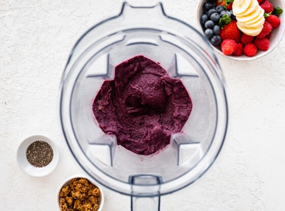 Frozen acai, berries, banana, and nut butter blended in a blender.