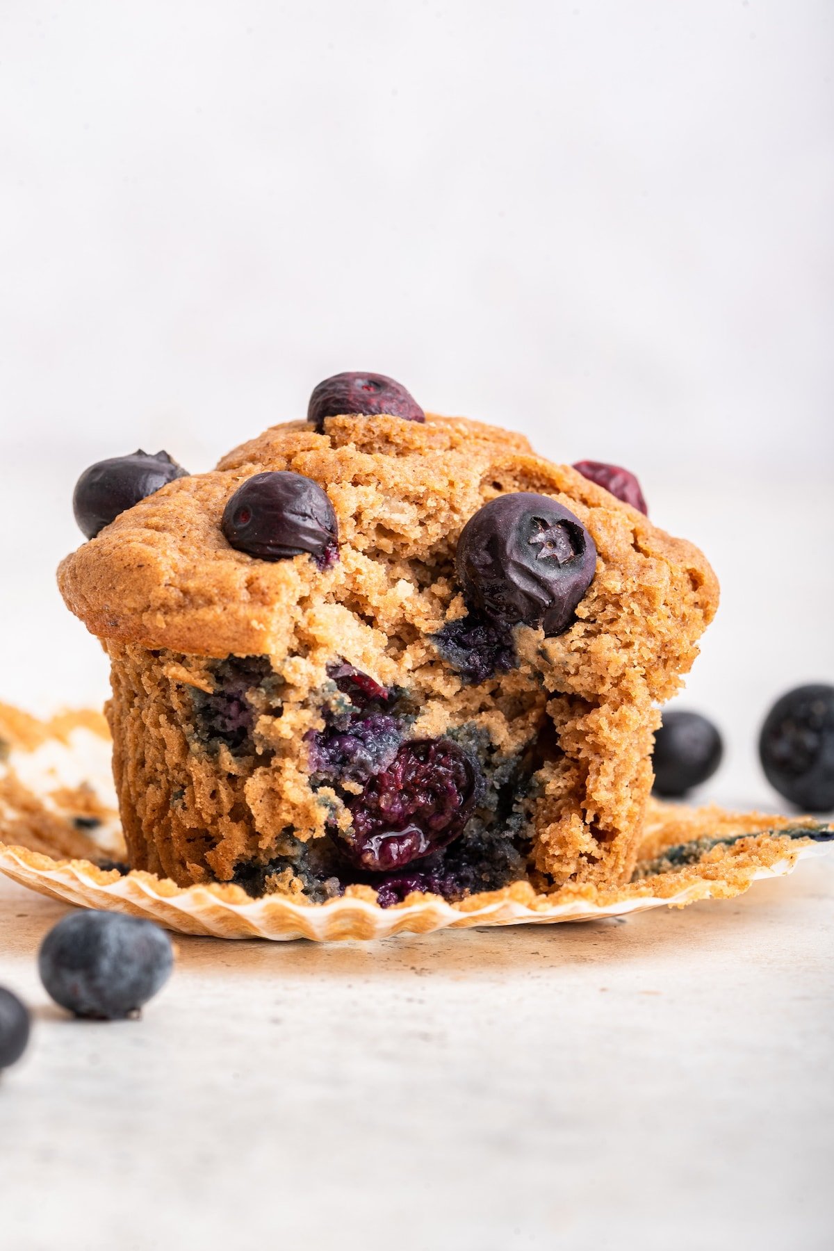 A blueberry protein muffin with a bite taken from it.