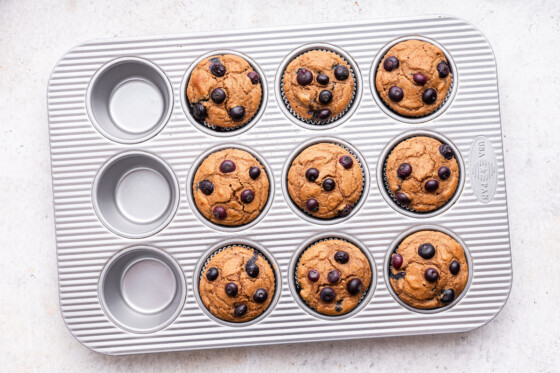 Finished blueberry protein muffins in a muffin tin.