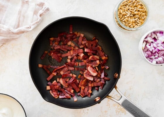 Cooked bacon pieces in a pan.