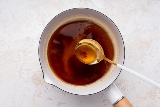 Browned butter in a sauce pan with a metal spoon.