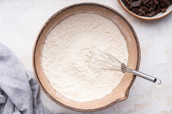 Flour in a large mixing bowl with a metal whisk.