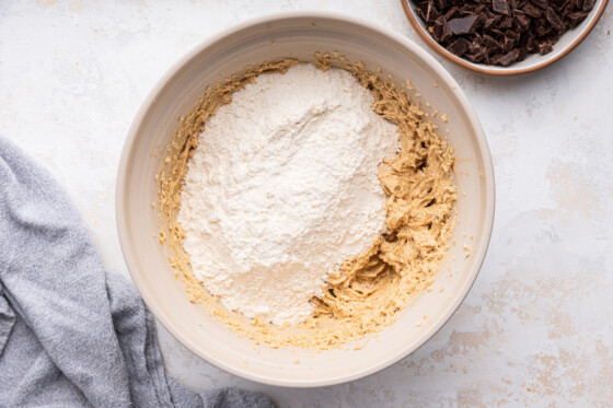 Flour added to a large mixing bowl with the cookie dough.