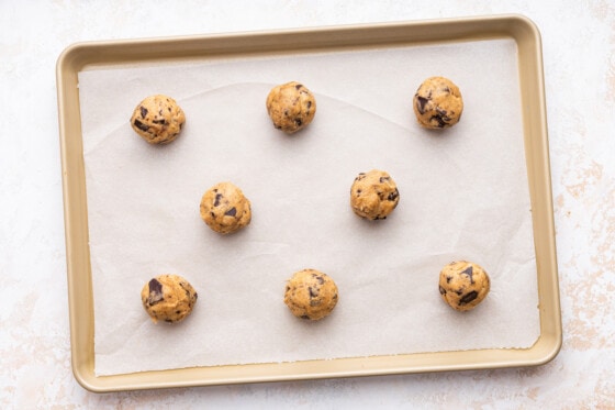 Small balls of cookie dough on a baking tray.