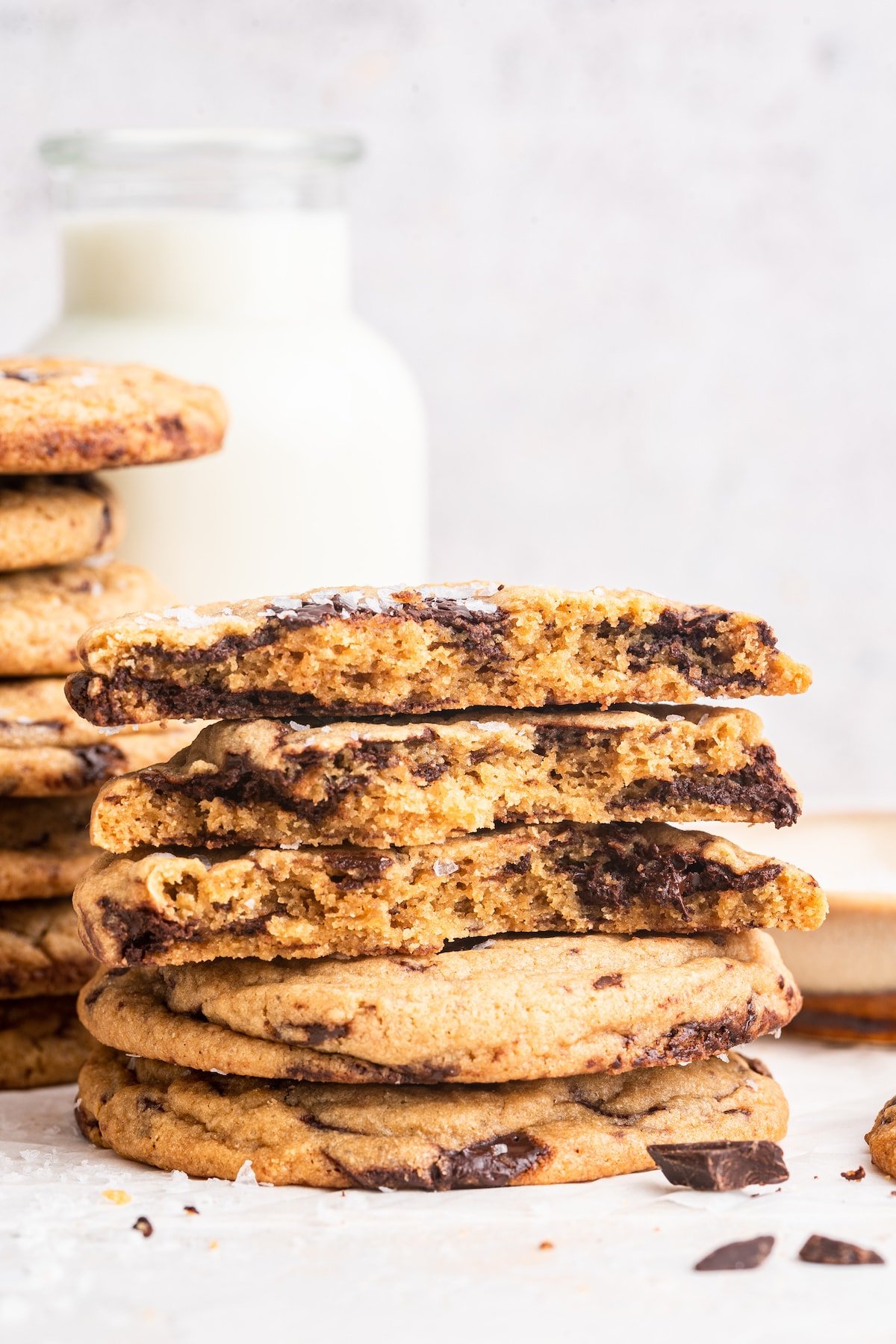 Brown butter chocolate chip cookies stacked on one another with three cookies having been split in half.